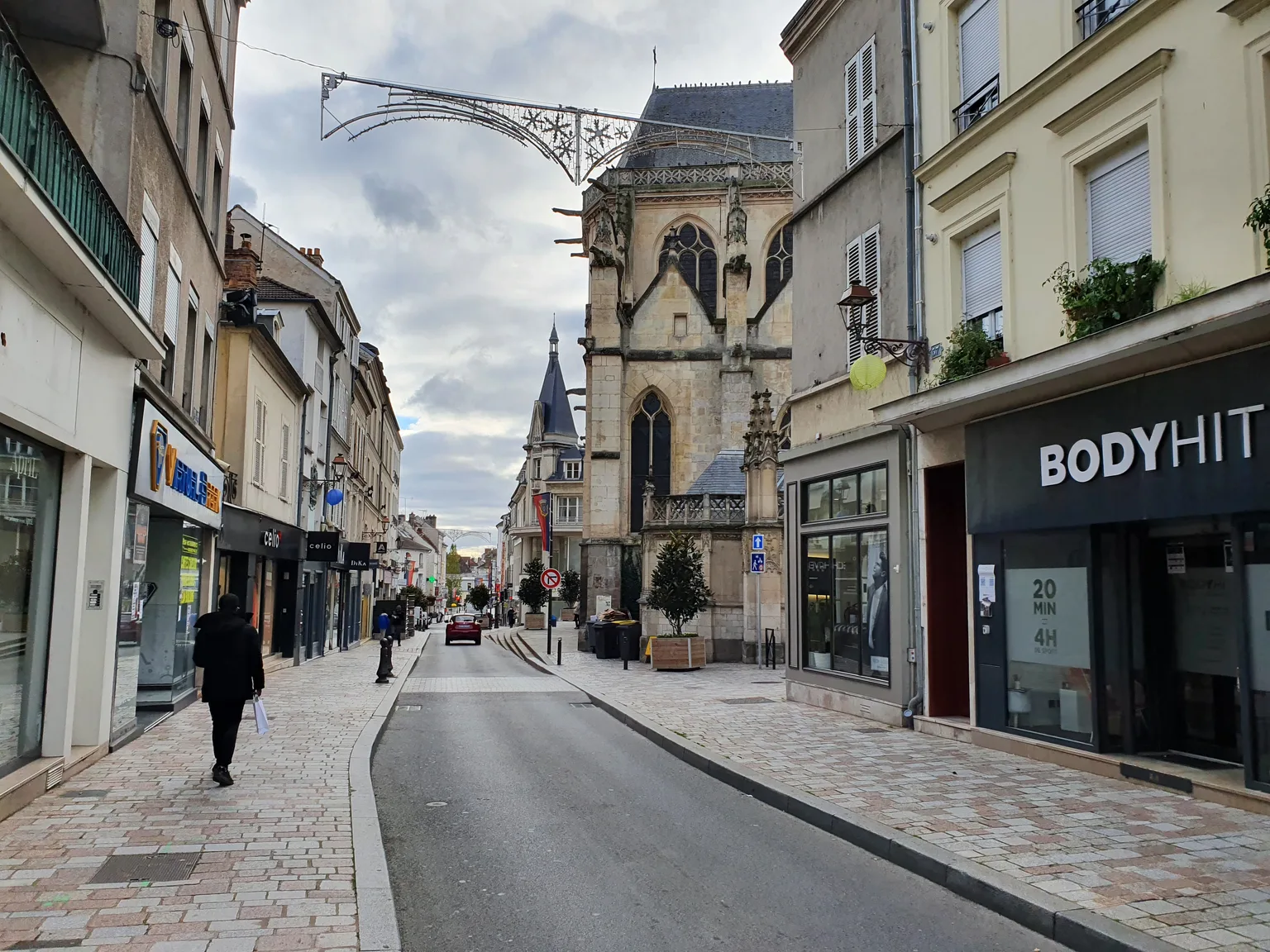 Rue Saint-Aspais à Melun, avec l’église et les façades des immeubles du centre ancien.