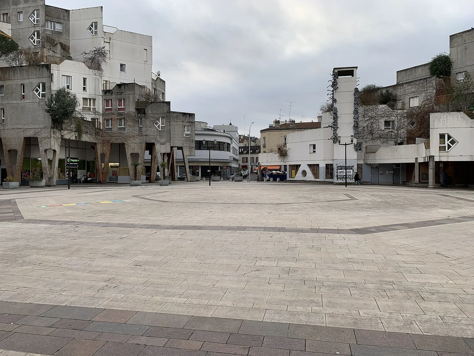 Place Voltaire à Ivry-sur-Seine, entourée d’immeubles aux terrasses et volumes étagés.