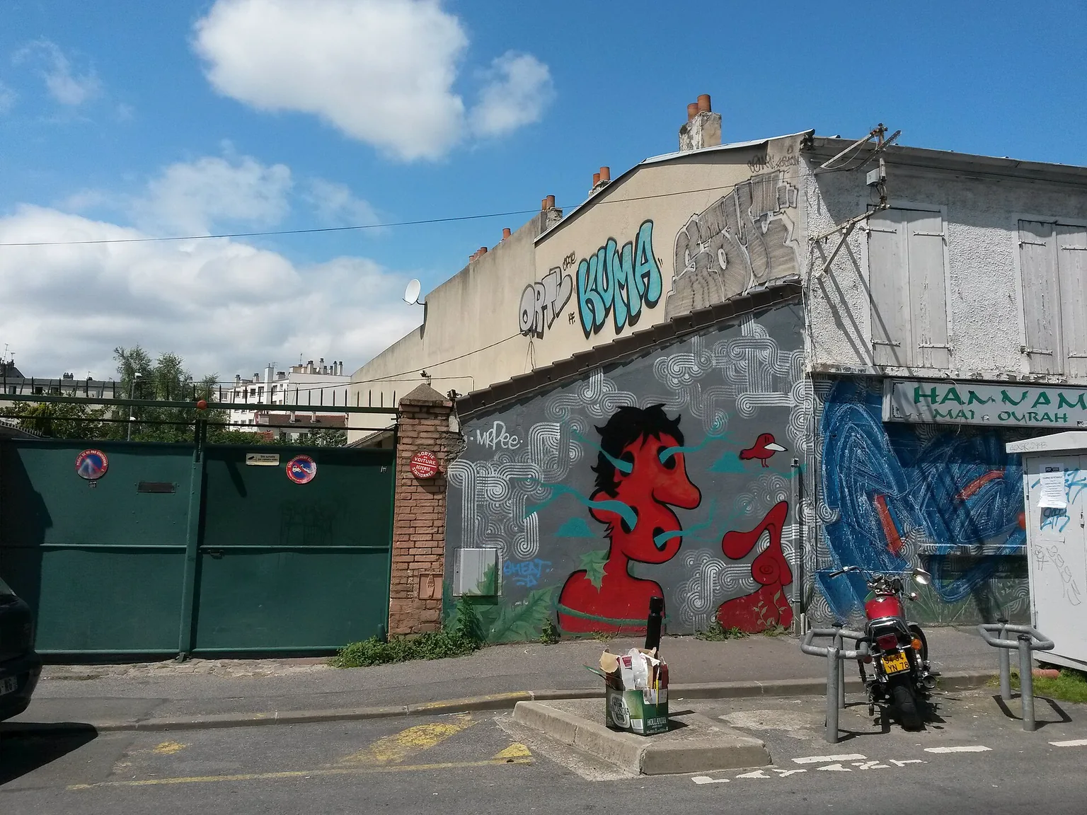 Bâtiments et portail le long de la rue Édouard-Vaillant à Montreuil, avec des peintures murales.