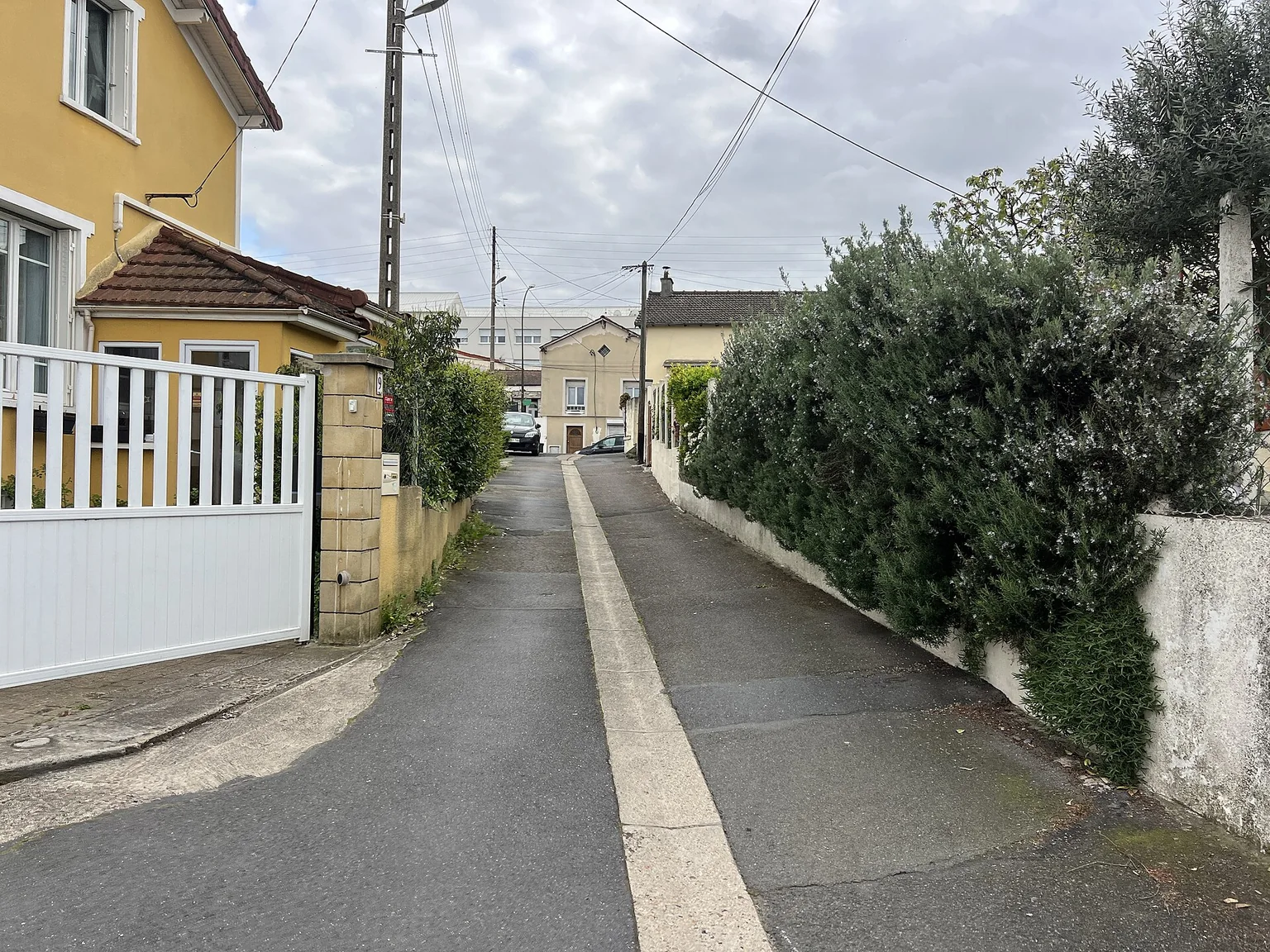Rue des Charmes à Argenteuil, entre maisons, murs de clôture et jardins.